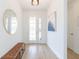 Bright foyer with elegant front door, bench seating and stylish light fixture at 33277 Rosewood Bark Way, Wesley Chapel, FL 33545
