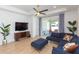 Cozy living room with a comfortable blue sectional, modern TV, and sliding glass doors leading to an outdoor patio at 33277 Rosewood Bark Way, Wesley Chapel, FL 33545