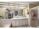 Well-lit bathroom with a large mirror, walk-in shower, and plenty of storage space for toiletries at 35020 Colony Hills Dr, Zephyrhills, FL 33541