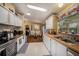 Bright kitchen with wood-look counters, white cabinets, and an adjacent dining space at 35020 Colony Hills Dr, Zephyrhills, FL 33541
