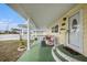View of the covered front porch with outdoor seating and painted green floor at 35020 Colony Hills Dr, Zephyrhills, FL 33541