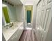 Bathroom featuring a white vanity with a marble countertop, wood-look floors and access to another bathroom at 365 Madeira Cir, Tierra Verde, FL 33715