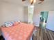 Inviting bedroom featuring wood-look floors, skylight, and coral-themed bedspread for a cozy feel at 365 Madeira Cir, Tierra Verde, FL 33715