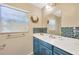 Updated bathroom featuring blue vanity, quartz counters, decorative mirror, and modern fixtures at 37419 Carter Ave, Dade City, FL 33523