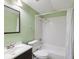 Well-lit bathroom with green walls, featuring a tiled shower and vanity at 4037 Chesswood Dr, Holiday, FL 34691