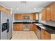Well-equipped kitchen boasting stainless steel appliances, tile flooring and wood cabinets at 4037 Chesswood Dr, Holiday, FL 34691