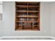 A wooden bookshelf with multiple shelves is built into the wall in this neutral hallway with gray carpet at 404 Westborough Ln, Safety Harbor, FL 34695