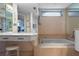 Bright bathroom features tub, neutral walls, and a vanity area with ample storage and a comfortable stool at 4464 46Th S Ave, St Petersburg, FL 33711