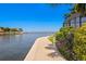 Waterfront property featuring a concrete walkway lined with lush greenery and tranquil water views at 4464 46Th S Ave, St Petersburg, FL 33711