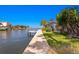 Waterfront home with private dock, lush landscaping, and serene water views on a sunny day at 4464 46Th S Ave, St Petersburg, FL 33711