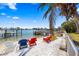 Waterfront backyard featuring beach, dock, and colorful adirondack chairs overlooking a picturesque view at 448 79Th S St, St Petersburg, FL 33707
