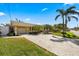 Exterior view featuring a concrete driveway leading to a home framed by lush landscaping at 448 79Th S St, St Petersburg, FL 33707