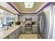 Kitchen area with stainless steel appliances, light stone counters and tile flooring at 448 79Th S St, St Petersburg, FL 33707