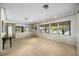 Large living room with terrazzo flooring, offering great natural light from large windows, enhancing the open feel at 448 79Th S St, St Petersburg, FL 33707