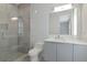 Modern bathroom with a floating vanity, white countertop, and a walk-in shower with glass door and tiled walls at 4604 W Lowell Ave, Tampa, FL 33629