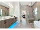 Bathroom features a double sink vanity, glass shower, and a bathtub at 4604 W Lowell Ave, Tampa, FL 33629