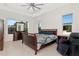 Bedroom with ceiling fan, a wood bed frame, two windows, and a wooden dresser at 4604 W Lowell Ave, Tampa, FL 33629