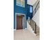 Elegant foyer featuring a modern wood door, staircase, and a vibrant blue accent wall at 4604 W Lowell Ave, Tampa, FL 33629