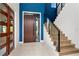 Bright foyer with a modern staircase, glass railings, and a striking blue accent wall at 4604 W Lowell Ave, Tampa, FL 33629