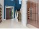 Bright foyer with a modern staircase, wine cellar, dark front door and a blue accent wall at 4604 W Lowell Ave, Tampa, FL 33629