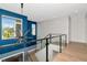 Hallway with decorative lighting, hardwood floors, and a black glass enclosed railing at 4604 W Lowell Ave, Tampa, FL 33629