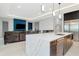 Open-concept kitchen with island with stainless steel sink, stainless steel refrigerator, and view of living area at 4604 W Lowell Ave, Tampa, FL 33629