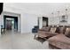 Open-concept living room featuring tile floors, modern lighting, and a view of the kitchen and entryway at 4604 W Lowell Ave, Tampa, FL 33629