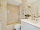 Bright bathroom with a shower-tub combo, white vanity, and decorative shelving at 6208 Forrestal Dr, Tampa, FL 33625