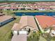 Aerial view of a home surrounded by a serene lake and lush landscaping in a vibrant community at 624 Maraviya Blvd, Nokomis, FL 34275