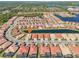Aerial view of a residential area with a lake surrounded by houses with red roofs and green lawns at 624 Maraviya Blvd, Nokomis, FL 34275