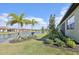 Beautifully landscaped backyard with lush grass, mature trees, and a serene waterfront view at 624 Maraviya Blvd, Nokomis, FL 34275