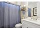 Bathroom featuring a vanity with white countertops, a toilet, and a blue shower curtain creating a modern and clean space at 624 Maraviya Blvd, Nokomis, FL 34275