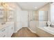 Spa-like main bathroom boasts a glass shower, soaking tub, and double vanity with white cabinets at 624 Maraviya Blvd, Nokomis, FL 34275