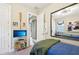 Well-lit bedroom with mounted TV, walk-in closet, and stylish mirror creating a comfortable and modern living space at 624 Maraviya Blvd, Nokomis, FL 34275