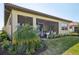 Back exterior of home with screened lanai showcasing outdoor living space and lush landscaping at 624 Maraviya Blvd, Nokomis, FL 34275