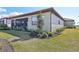 Rear exterior view of a house with screened lanai, lush lawn, and well-maintained landscaping at 624 Maraviya Blvd, Nokomis, FL 34275