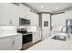 Bright kitchen features white cabinets, stainless steel appliances, quartz countertops, and stylish subway tile backsplash at 624 Maraviya Blvd, Nokomis, FL 34275