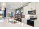 Modern kitchen with a large island, stainless steel appliances, and sleek white cabinetry offering ample storage space at 624 Maraviya Blvd, Nokomis, FL 34275