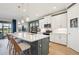 Stylish kitchen featuring white cabinets, quartz countertops, stainless steel appliances, and an island with bar seating at 624 Maraviya Blvd, Nokomis, FL 34275