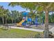 Community playground with slides and climbing structures, surrounded by mature trees and green space at 624 Maraviya Blvd, Nokomis, FL 34275
