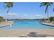 Lagoon style community pool with beach entry, surrounded by palm trees and waterfront homes at 624 Maraviya Blvd, Nokomis, FL 34275