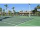 Community tennis courts with covered seating areas, surrounded by lush palm trees at 624 Maraviya Blvd, Nokomis, FL 34275