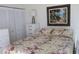Cozy bedroom with a comfortable bed with floral bedding and a painting of a beach scene at 6287 Bahia Del Mar Cir # 101, St Petersburg, FL 33715