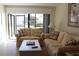Bright living room featuring tile floors, cozy sofas, and sliding glass doors to a water view at 6287 Bahia Del Mar Cir # 101, St Petersburg, FL 33715