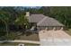 Expansive home with a three-car garage, mature landscaping, and a well-manicured front lawn visible in aerial view at 70 Deerpath Dr, Oldsmar, FL 34677