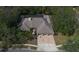 Aerial shot showcasing home with mature trees, patterned driveway, and well-kept lawn at 70 Deerpath Dr, Oldsmar, FL 34677