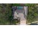 Overhead image of home featuring screened-in pool, beautiful roof lines, and surrounded by trees at 70 Deerpath Dr, Oldsmar, FL 34677