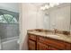 Bathroom with a granite vanity, sink, wood cabinetry, and tiled shower and tub at 70 Deerpath Dr, Oldsmar, FL 34677