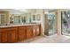 Bathroom featuring double sink vanity with granite countertop and glass enclosed shower with exterior access at 70 Deerpath Dr, Oldsmar, FL 34677