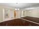 Dining room with dark wood floors, large mirrored wall, and chandelier lighting at 70 Deerpath Dr, Oldsmar, FL 34677